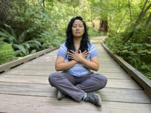 Melissa Roxas acupuncturist and herbalist with her hands over her chest power of belief and mind-body connection