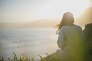 woman with chronic illness looking at the ocean belief in healing
