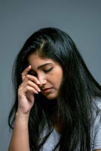 Woman resting her hands on forehead, showing nervous system dysregulation